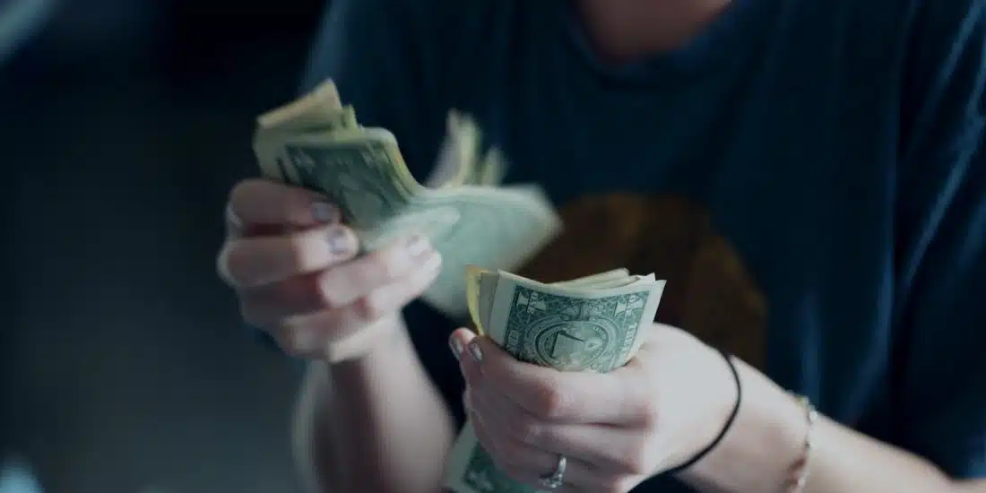 focus photography of person counting dollar banknotes